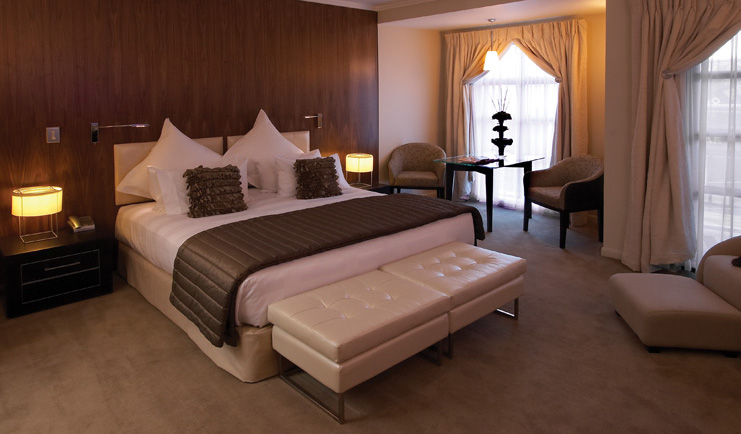 Sofitel Queenstown Otago and Fiordland deluxe bedroom with sitting area and armchair