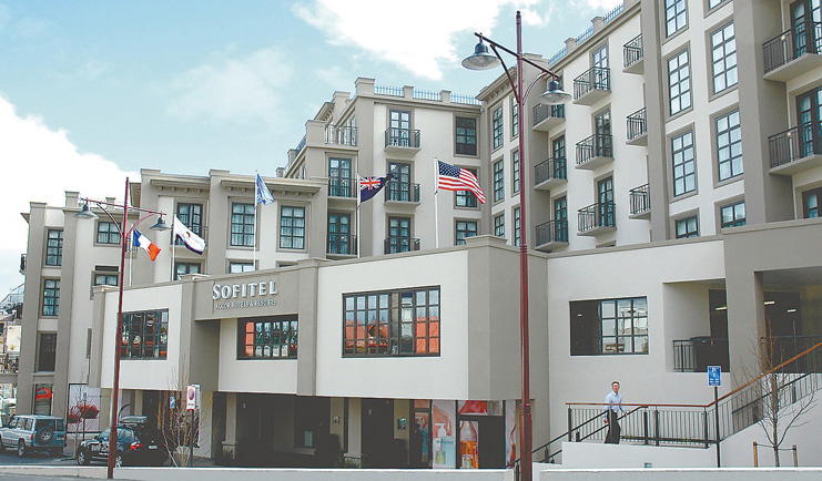 Sofitel Queenstown Otago and Fiordland exterior white and grey building with several flags