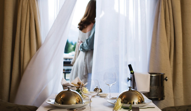 Sofitel Queenstown Otago and Fiordland room service couple standing in front of a window with room service