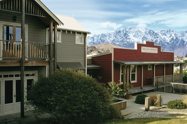 The Dairy Otago and Fiordland exterior red lodge building with snowy mountain in the background 