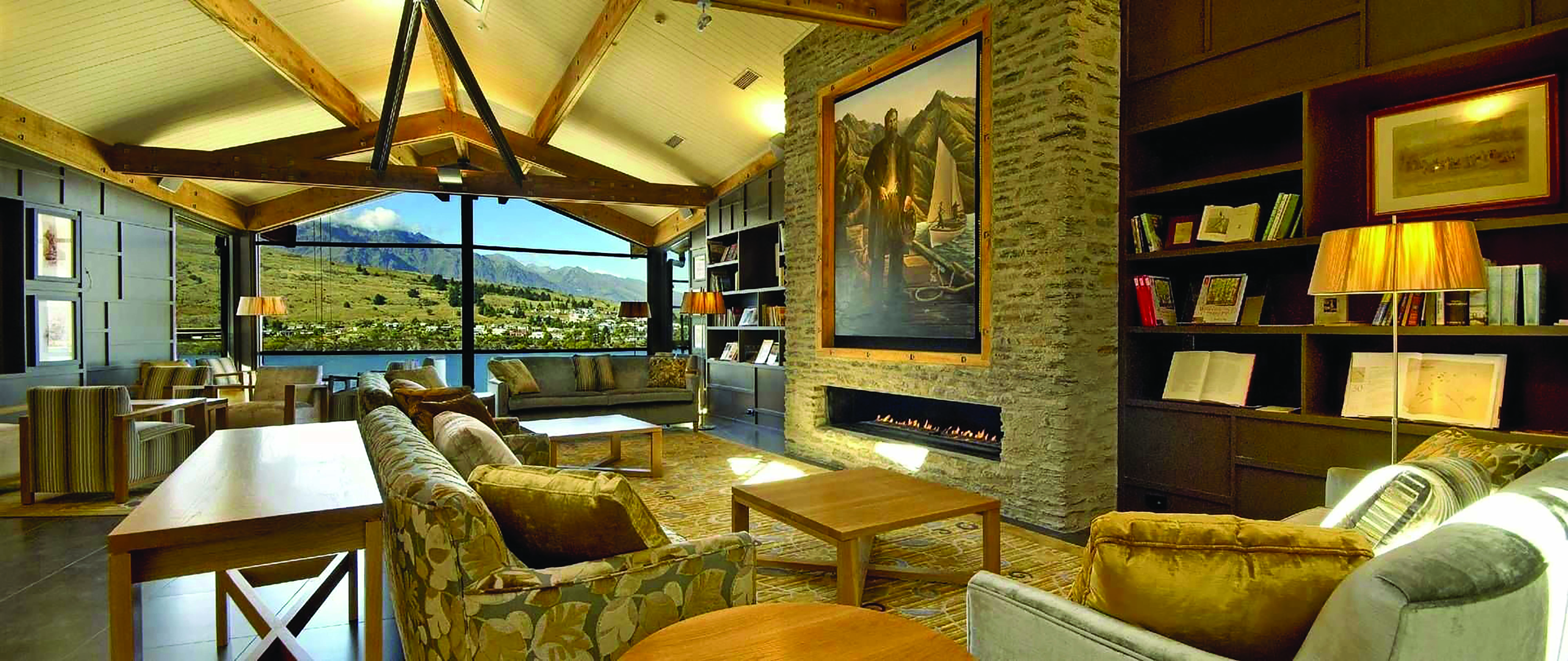 The Rees Hotel Otago and Fiordland lounge area with large painting fireplace and large window