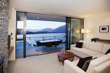 The Rees Hotel Otago and Fiordland suite living area and patio door to balcony with mountain and lake view