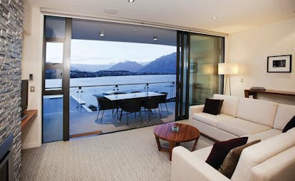 The Rees Hotel Otago and Fiordland suite living area and patio door to balcony with mountain and lake view