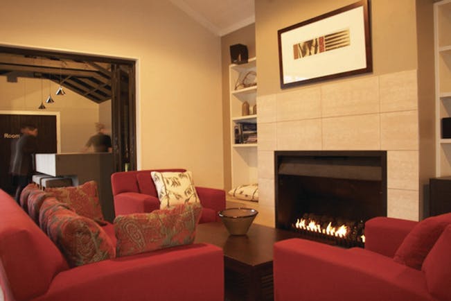 Peppers Parehua Wairarapa Pavilion restaurant seating area with red sofas and fireplace