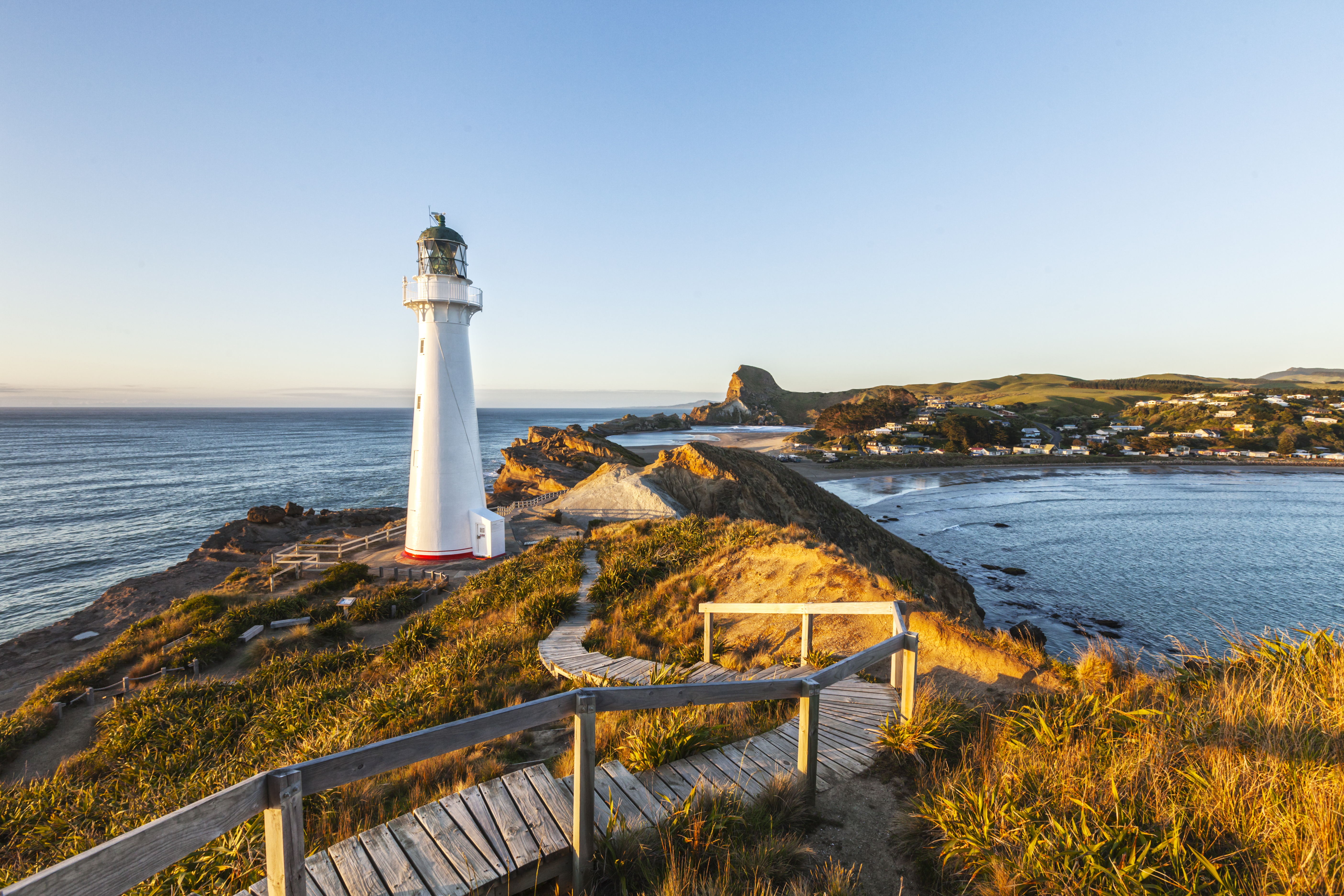 Castlepoint Lighthouse in Wairarapa, rugged headland, sea, sunset
