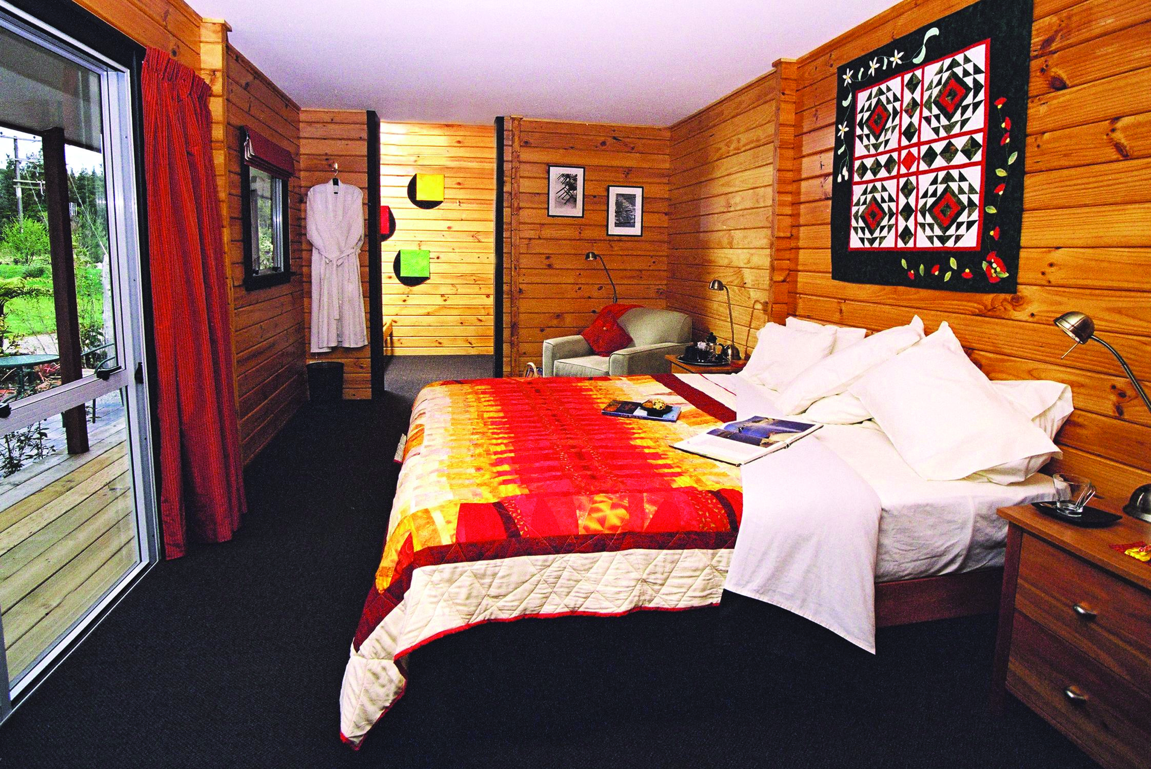 Westwood Country House master suite, double bed, wood panelled walls, artwork