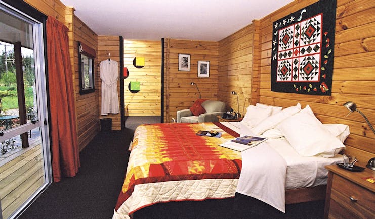 Westwood Country House master suite, double bed, wood panelled walls, artwork