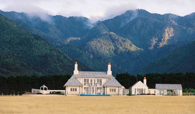 Wharekauhau Lodge Wairarapa lodge mountain exterior view of lodge complex in front of wooded mountains