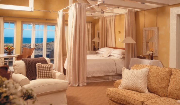 Wharekauhau Lodge Wairarapa suite with four poster bed sofa and sea view