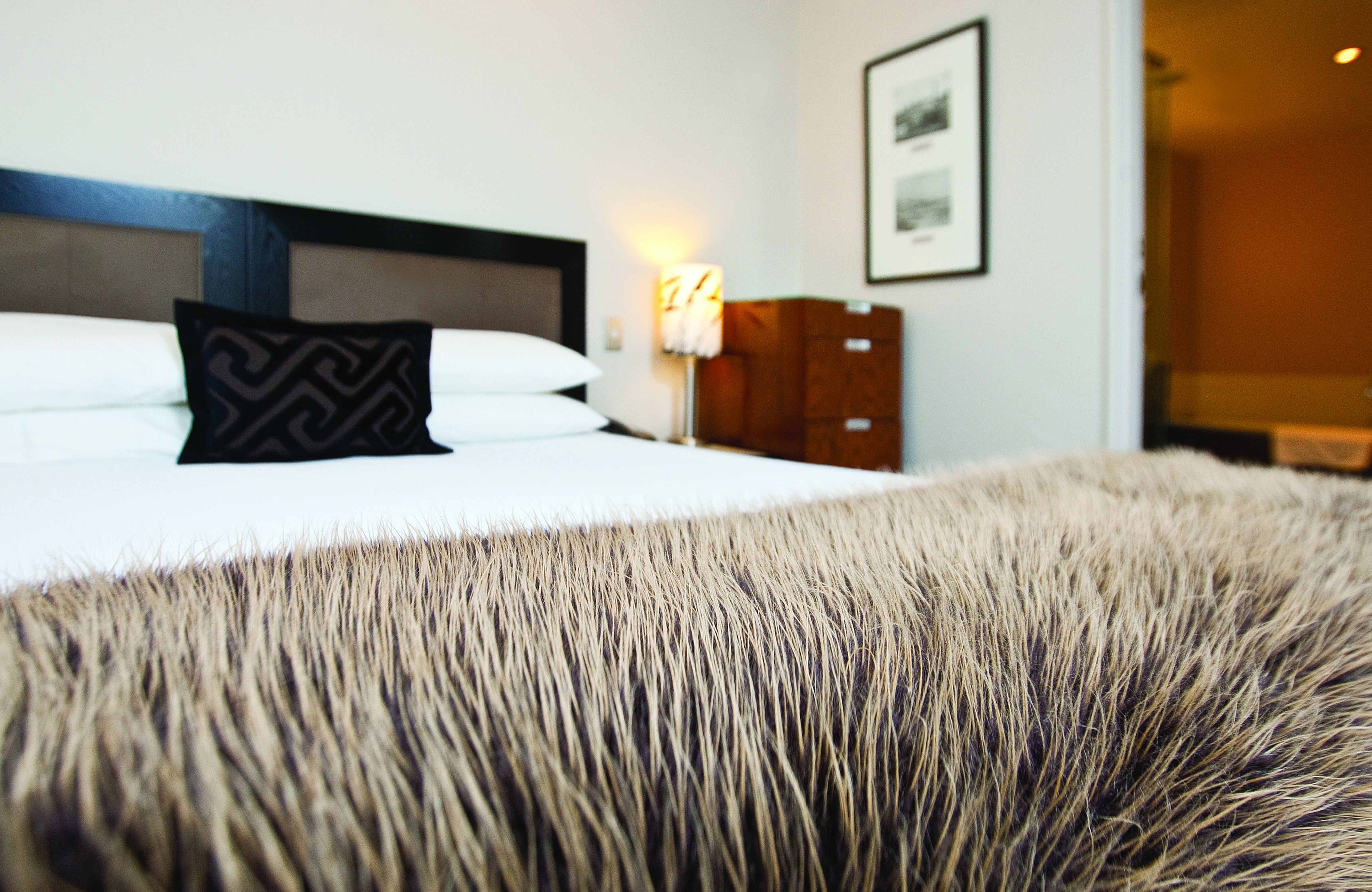 Bolton Hotel Wellington bedroom with faux fur blanket and view to bathroom