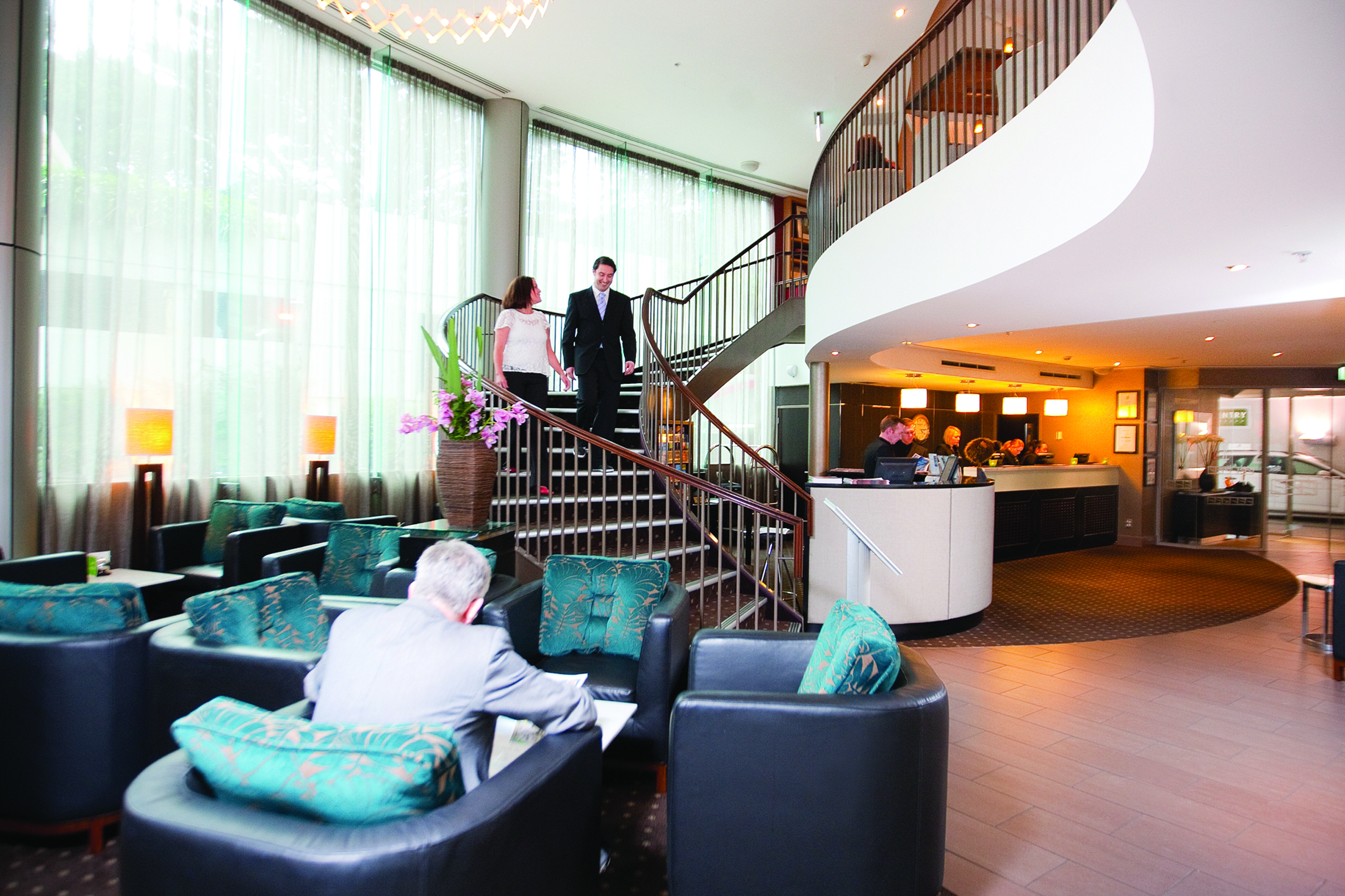 Bolton Hotel Wellington lobby couple walking down stairs to lobby with seating area