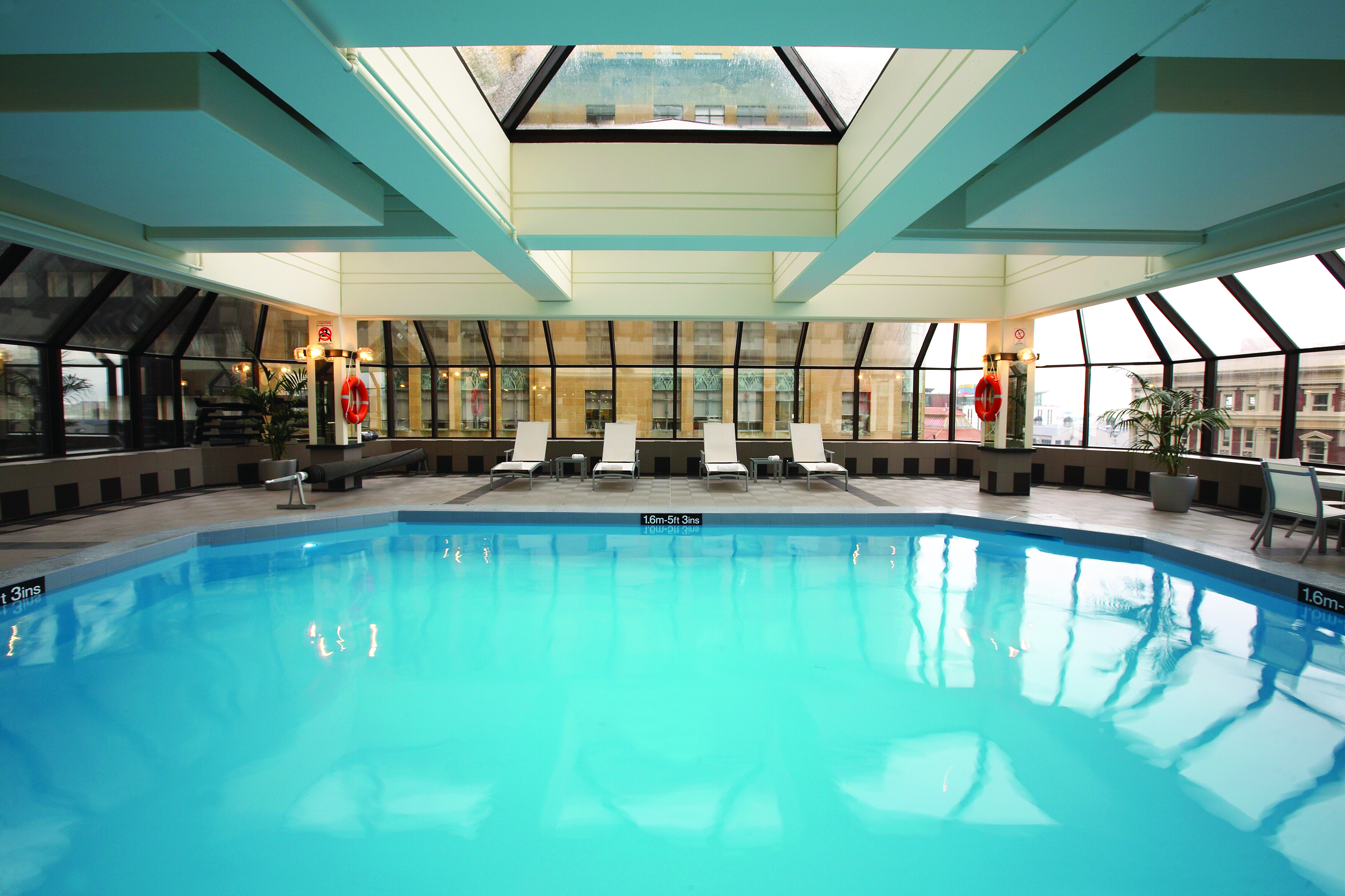 The Intercontinental Wellington indoor pool with panoramic windows city view and loungers