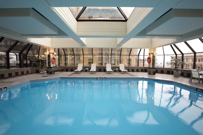 The Intercontinental Wellington indoor pool with panoramic windows city view and loungers