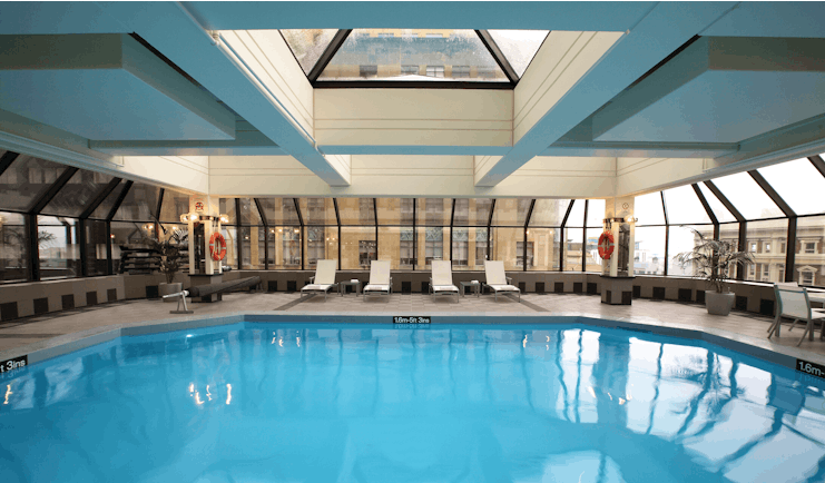 The Intercontinental Wellington indoor pool with panoramic windows city view and loungers