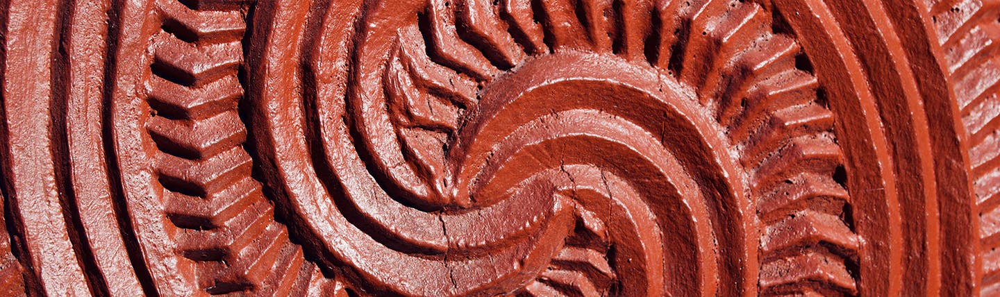 Red carving on Maori statue