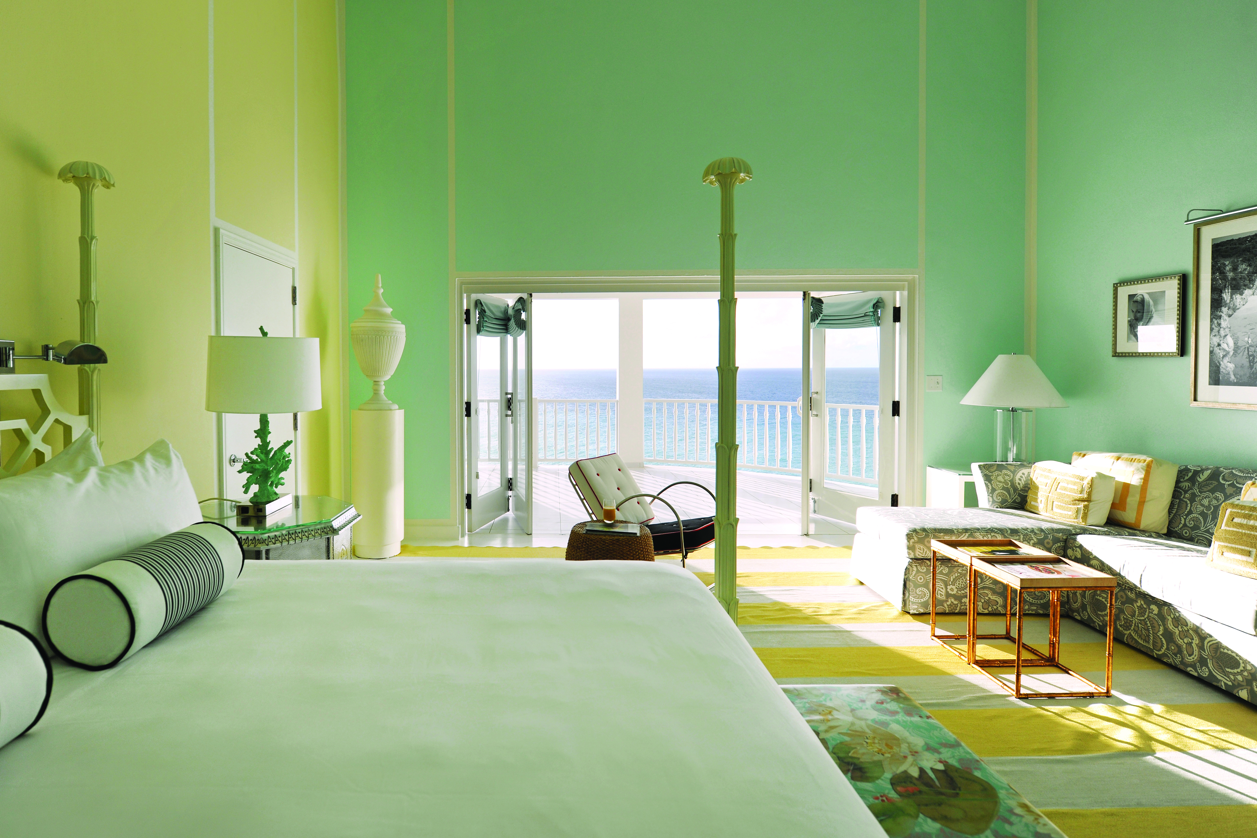 Malliouhana premium room with pastel colours, large double bed and sofa, with balcony with sea views