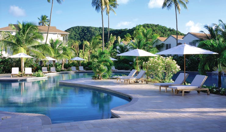 Carlisle Bay Antigua pool palm trees and sun loungers