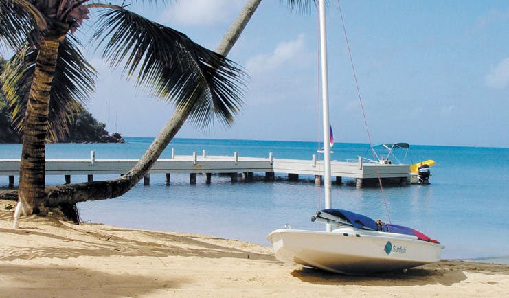 Carlisle Bay Antigua water sports boat on sand jetty beach ocean palm tree