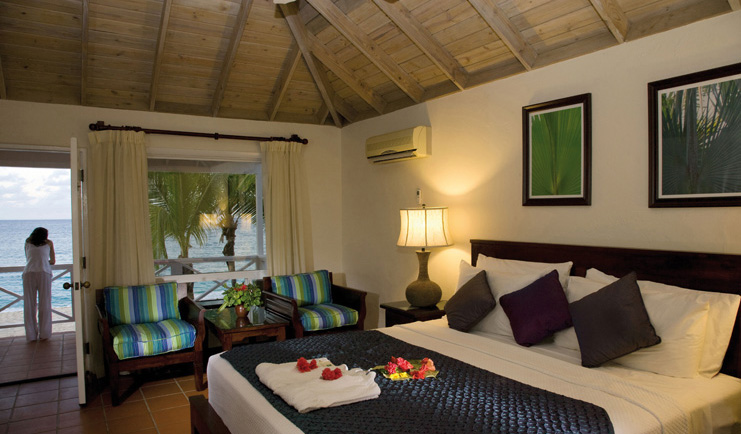 Galley Bay Antigua deluxe room bed armchairs private terrace overlooking sea