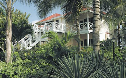 Galley Bay Antigua deluxe rooms exterior building surrounded by palm trees and greenery
