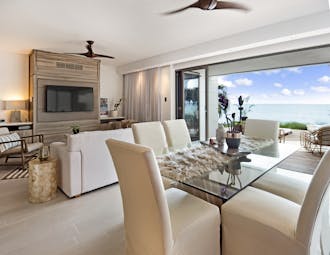 Dining room of villa at Hodges Bay Resort, bright modern decor, view of sea