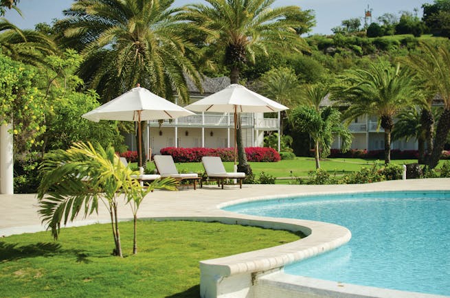 Inn at English Harbour Antigua Poolside sun loungers umbrellas palm trees