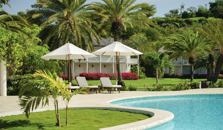 Inn at English Harbour Antigua Poolside sun loungers umbrellas palm trees