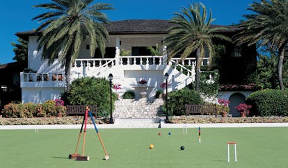 Jumby Bay Antigua estate house exterior hotel building palm trees games lawn