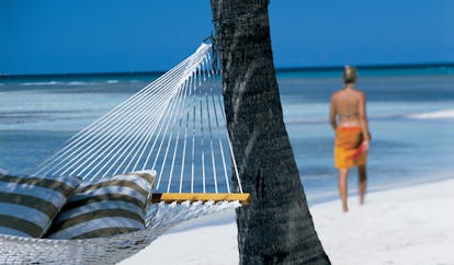 Jumby Bay Antigua hammock on white sandy beach palm tree