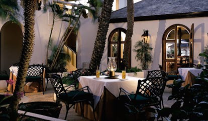 Jumby Bay Antigua outdoor dining area tables chairs palm trees