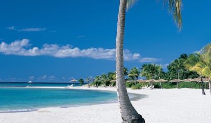 Jumby Bay Antigua sandy beach white sandy beach palm trees sea