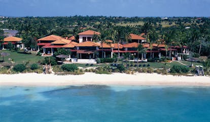Jumby Bay Antigua villa exteriors buildings on beachfront white sandy beach 
