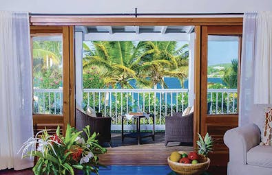 Nonsuch Bay Antigua premium beach suite lounge leading to balcony and outdoor seating overlooking beach