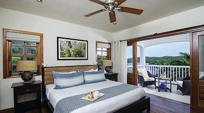 Nonsuch Bay Antigua deluxe suite bedroom leading to balcony and outdoor seating area