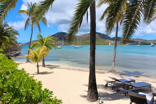 South Point beach, white sandy beach, palm trees, clear blue waters, sun loungers