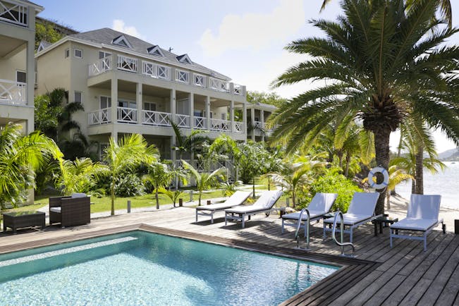 South Point pool, sun loungers, palm trees, decking, hotel building in background