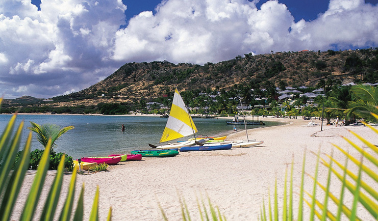 St James's Club Antigua kayaks moored on beach white sand coastline in background