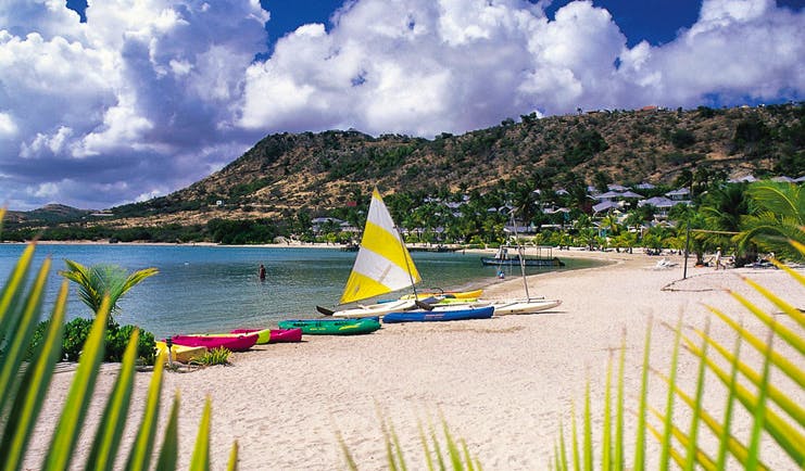 St James's Club Antigua kayaks moored on beach white sand coastline in background
