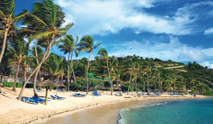 St James's Club Antigua beach white sand  sun loungers umbrellas palm trees