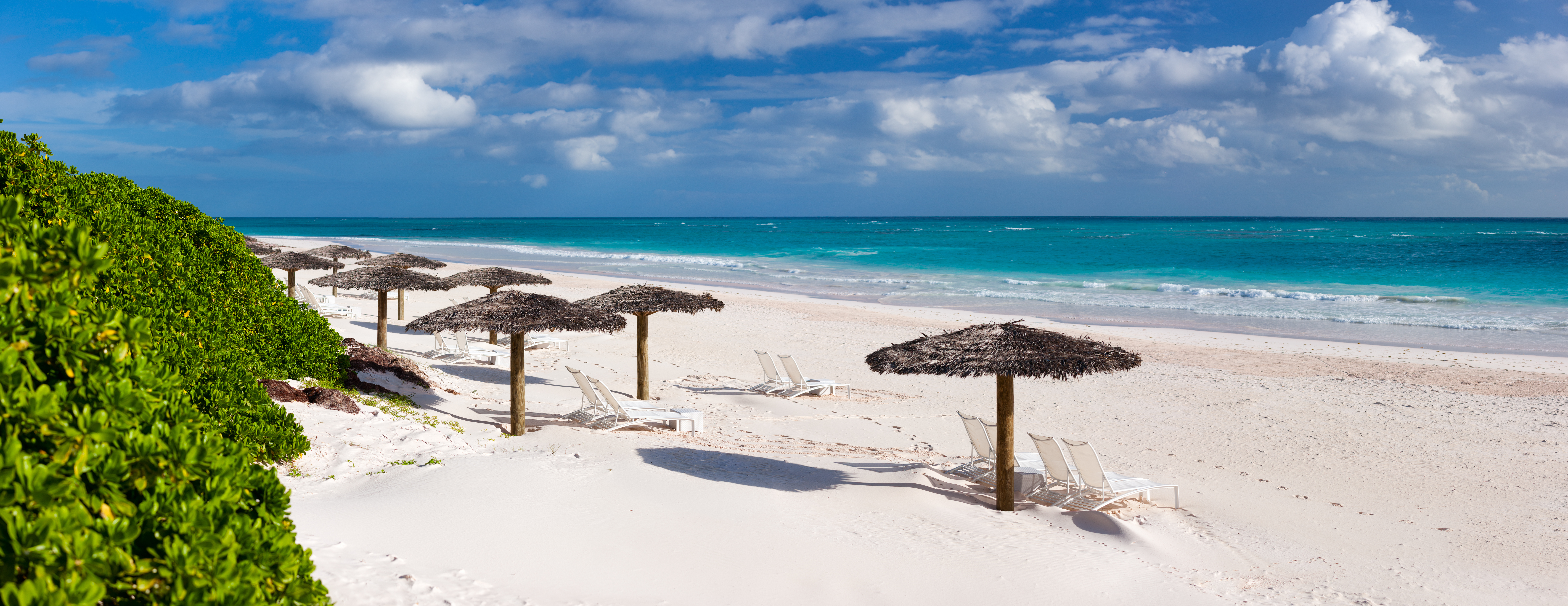 Beach in the Bahamas, white sand, clear blue sea, umbrellas