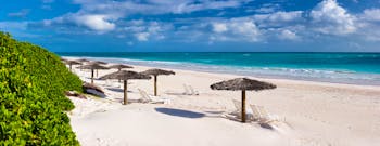 Beach in the Bahamas, white sand, clear blue sea, umbrellas