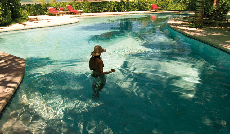Kamalame Cay Bahamas outdoor pool loungers greenery trees