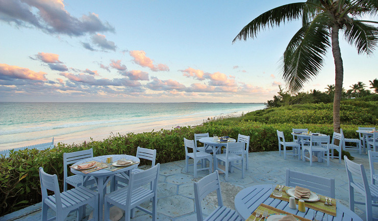 Pink Sands Bahamas blue bar outdoor dining area white tables garden and ocean view
