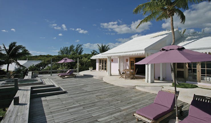 Pink Sands Bahamas deck white bungalow sun loungers umbrellas hot tub