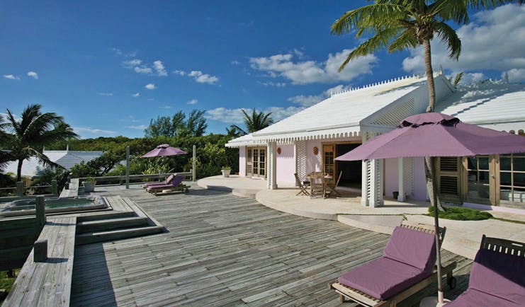 Pink Sands Bahamas deck white bungalow sun loungers umbrellas hot tub