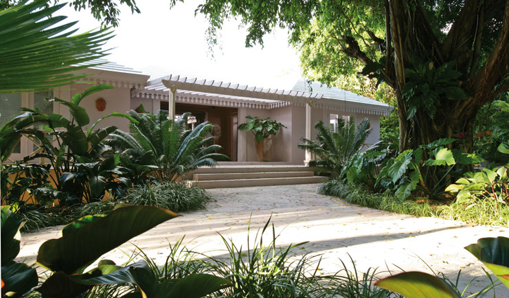 Pink Sands Bahamas hotel exterior white bungalow building pathway greenery palm trees