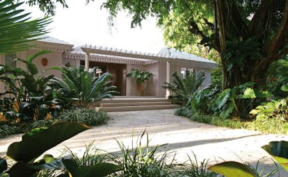 Pink Sands Bahamas hotel exterior white bungalow building pathway greenery palm trees