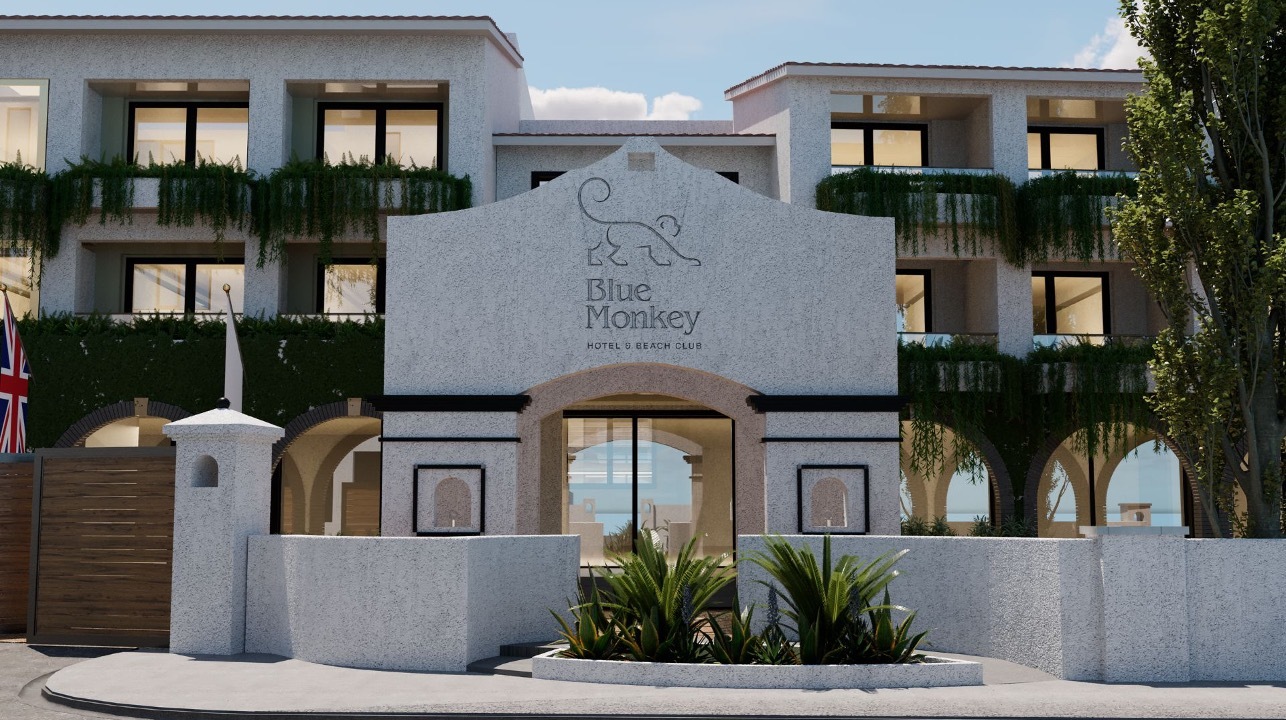 Blue Monkey Hotel exterior with whitewashed walls, balconies with hanging vines and plants, and the central entrance