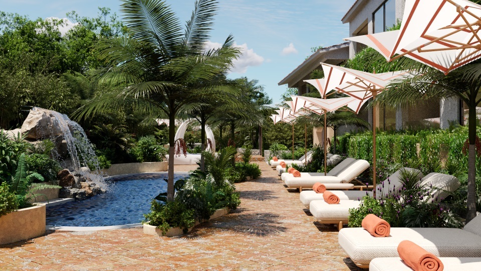 Blue Monkey Hotel tropical themed swimming pool with freeform shape, waterfall, and lots of plants, trees and shrubs next to a row of sun loungers