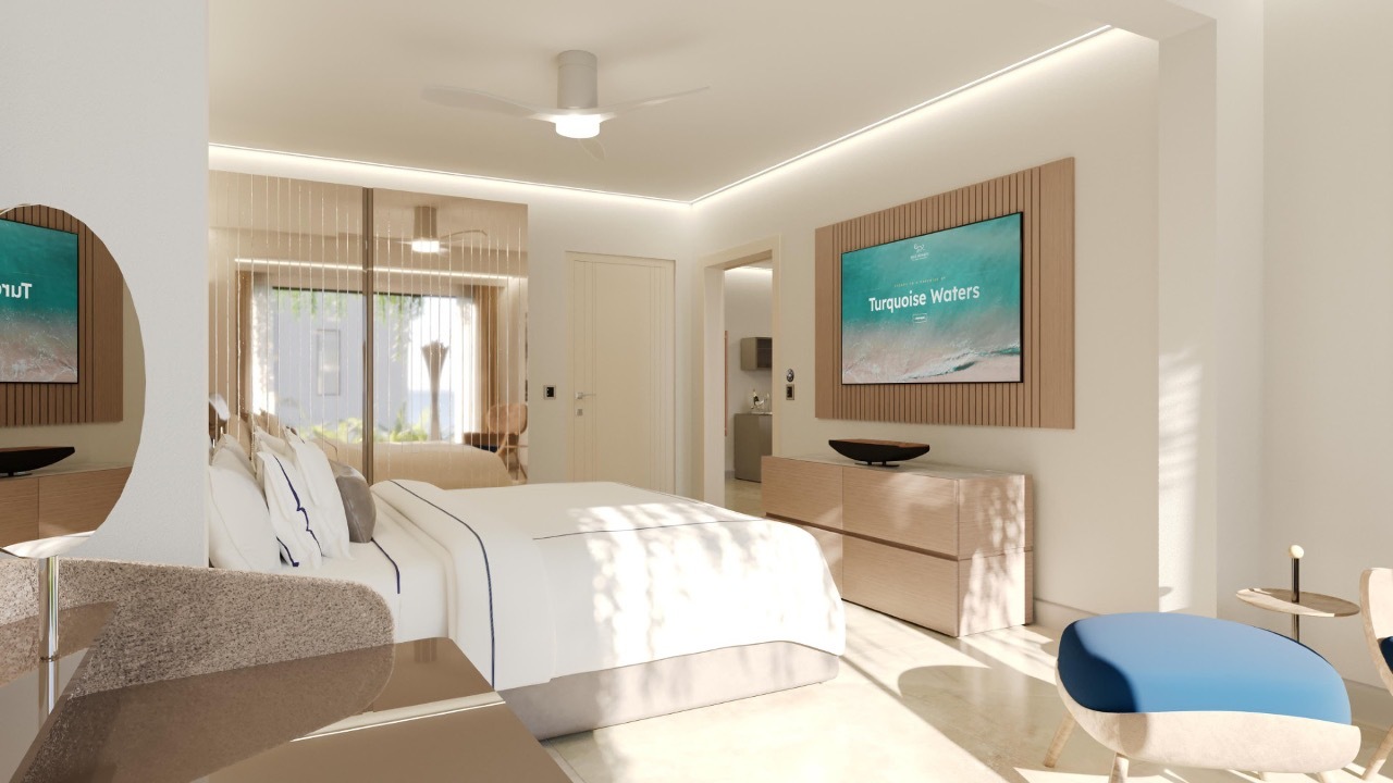 Blue Monkey Hotel view into the whitewashed bedroom, with large king bed and white linens, light wood furnishings, and large mirror